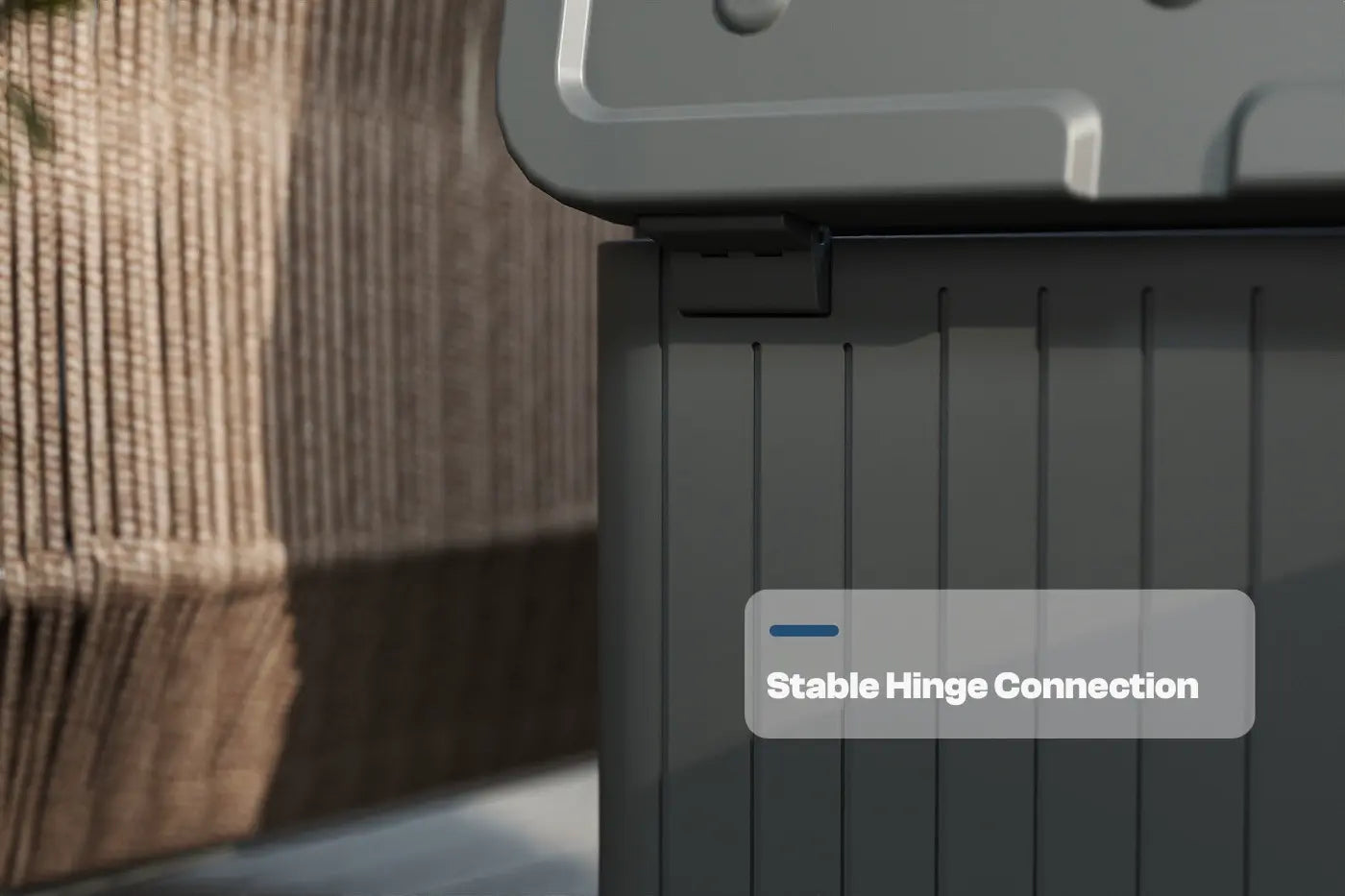 Dark gray storage box with a stable hinge connection label, blurred background