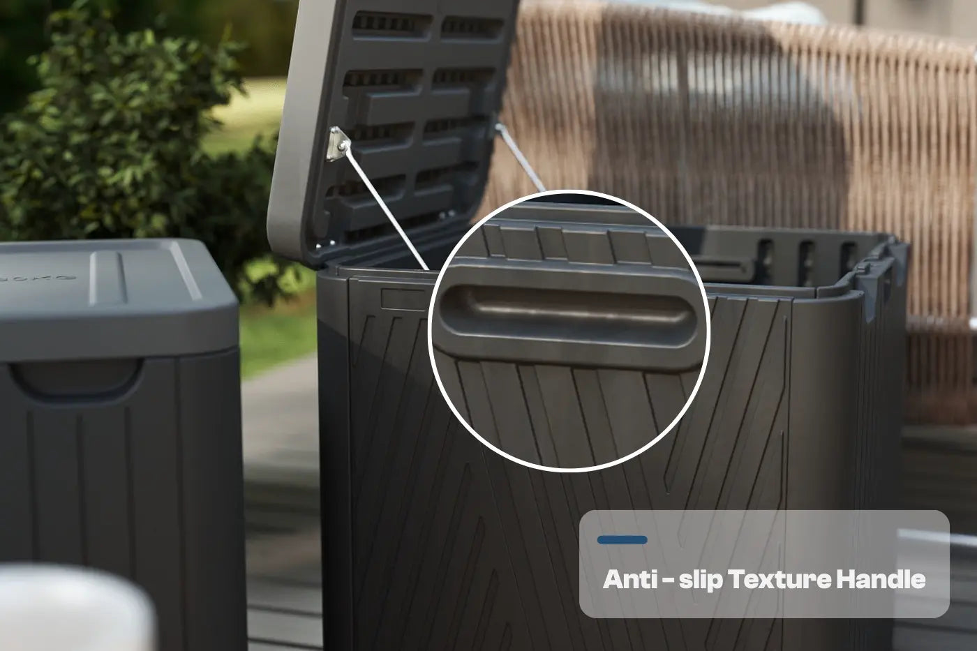 Black outdoor trash bin with open lid and anti-slip texture handle, surrounded by greenery.