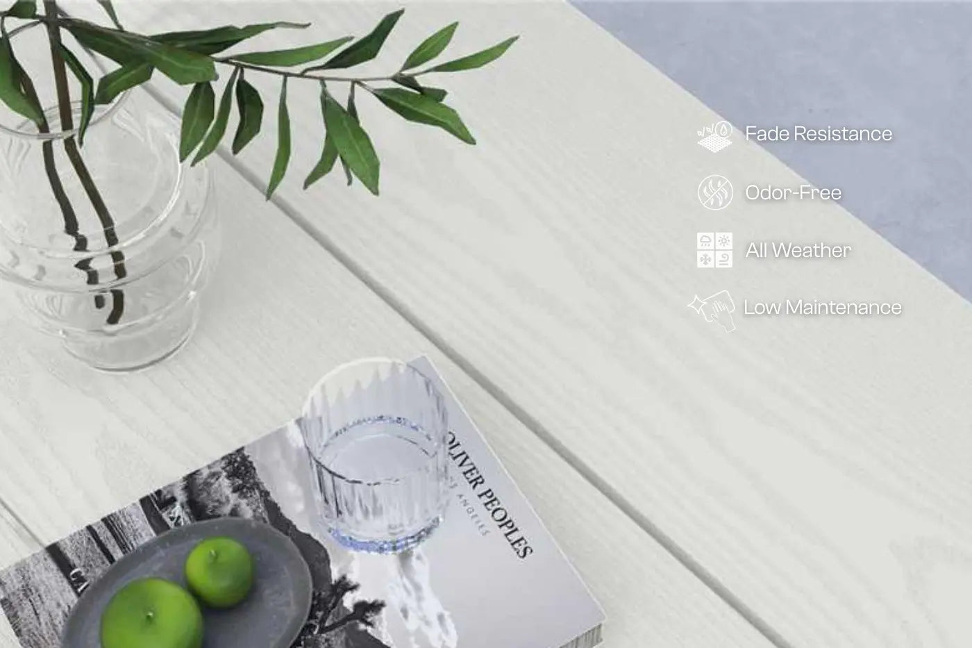 Table setting with a vase, apples, and a magazine on a white surface.
