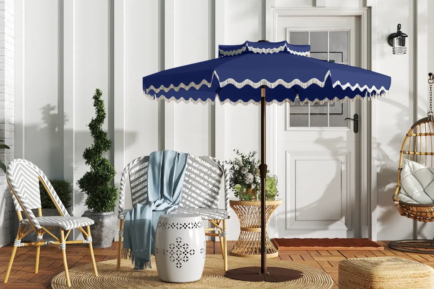 Blue outdoor umbrella with white trim on a patio with chairs and decor.