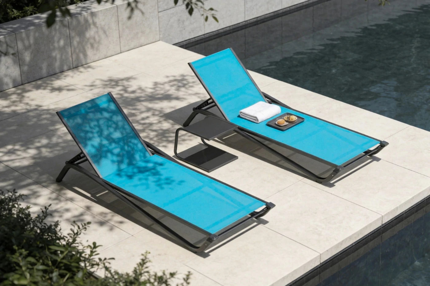 Two blue lounge chairs by a poolside with a towel and a plate on one of them.