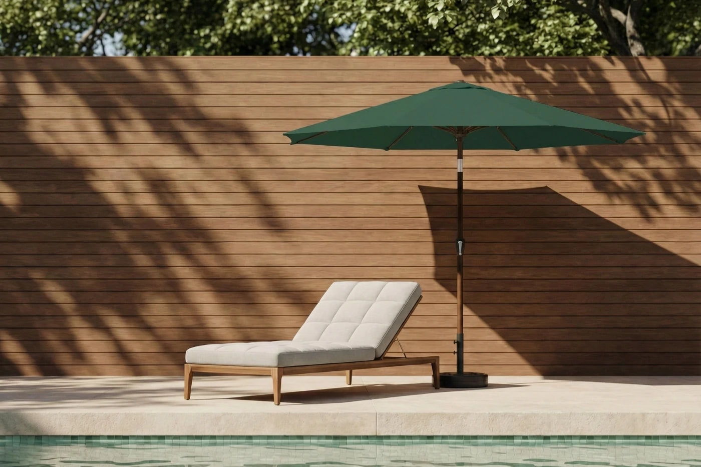 Chaise lounge with green umbrella by a poolside against a wooden wall
