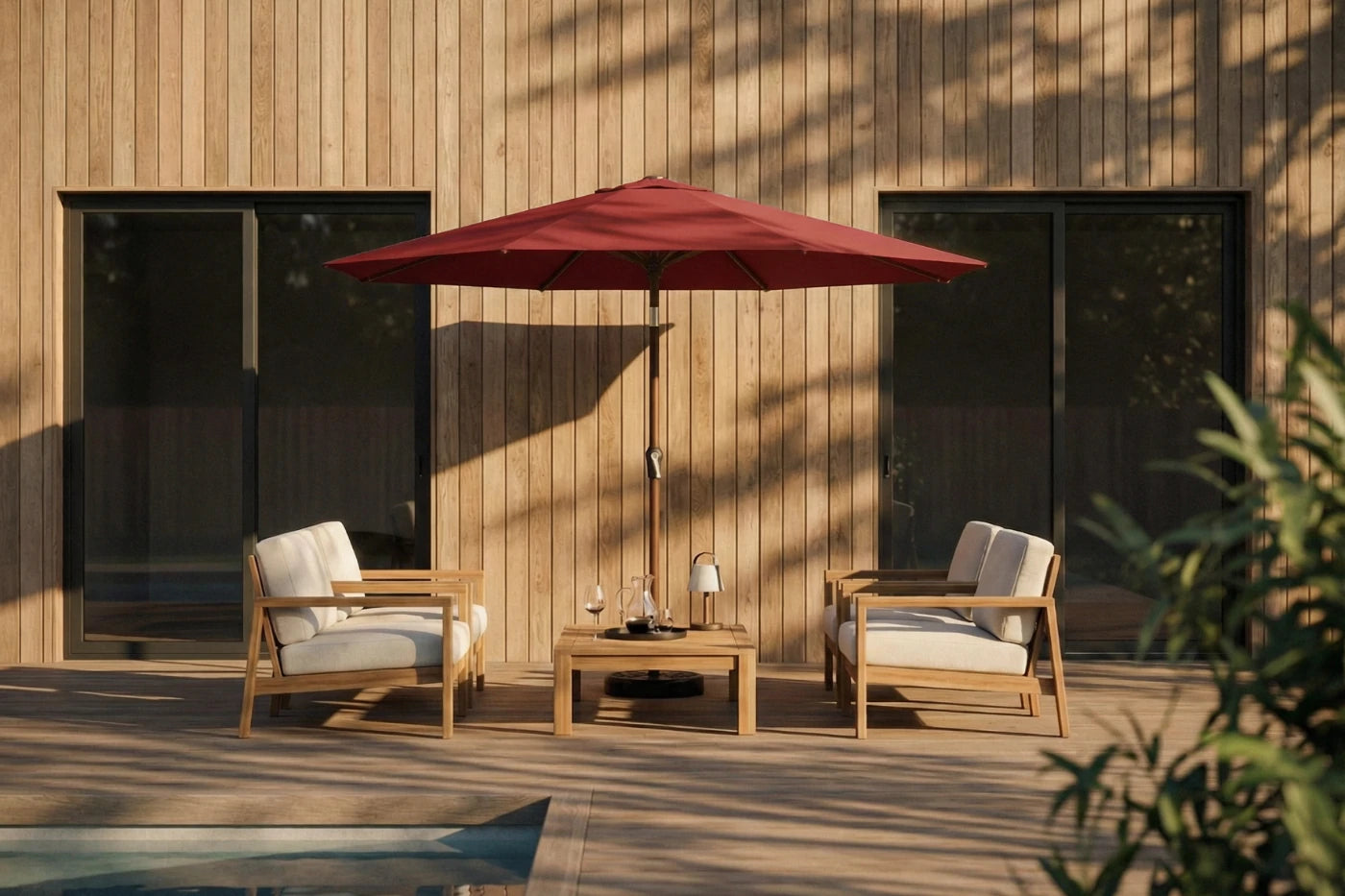 Outdoor patio set with two chairs, a table, and a red umbrella on a wooden deck.