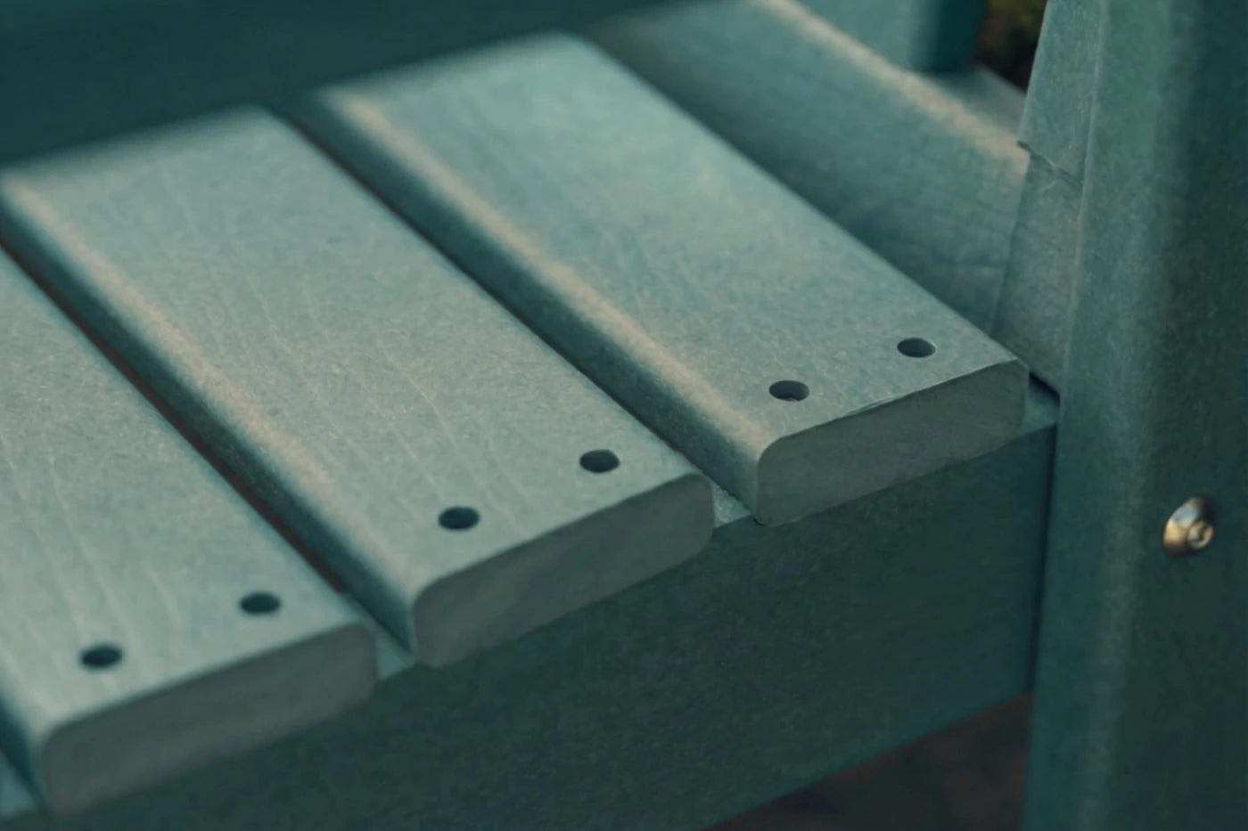 Close-up of a green wooden bench with slats