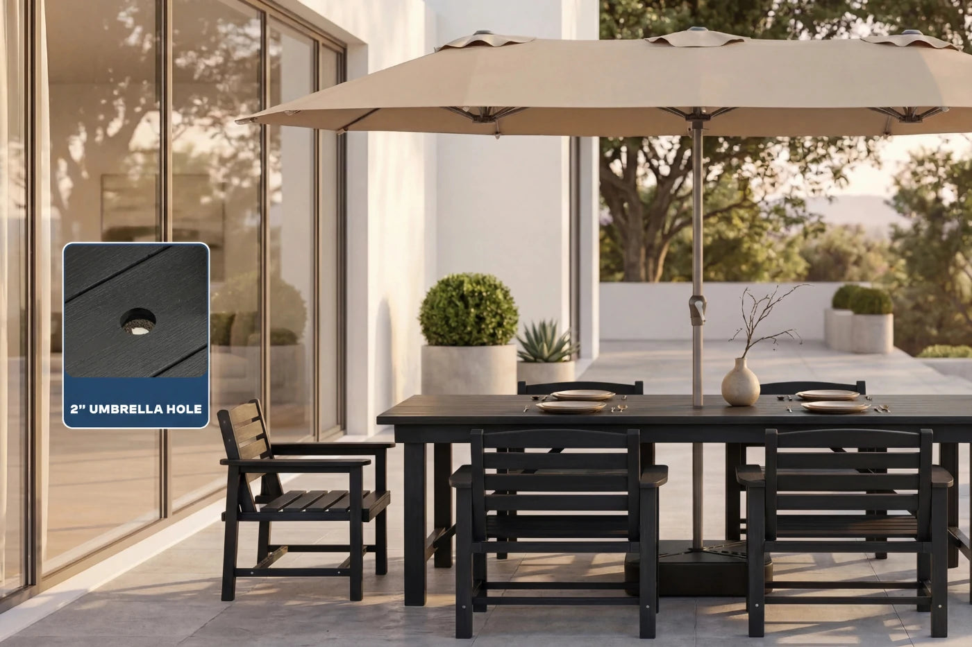 Outdoor patio set with a large beige umbrella and black furniture on a patio.