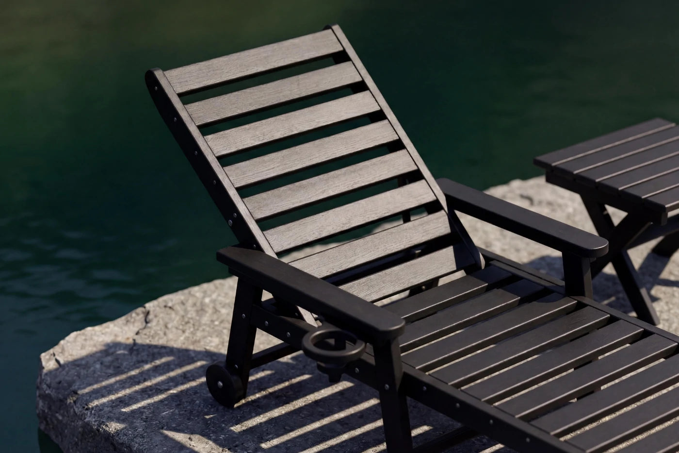 Wooden lounge chair with ottoman by a body of water