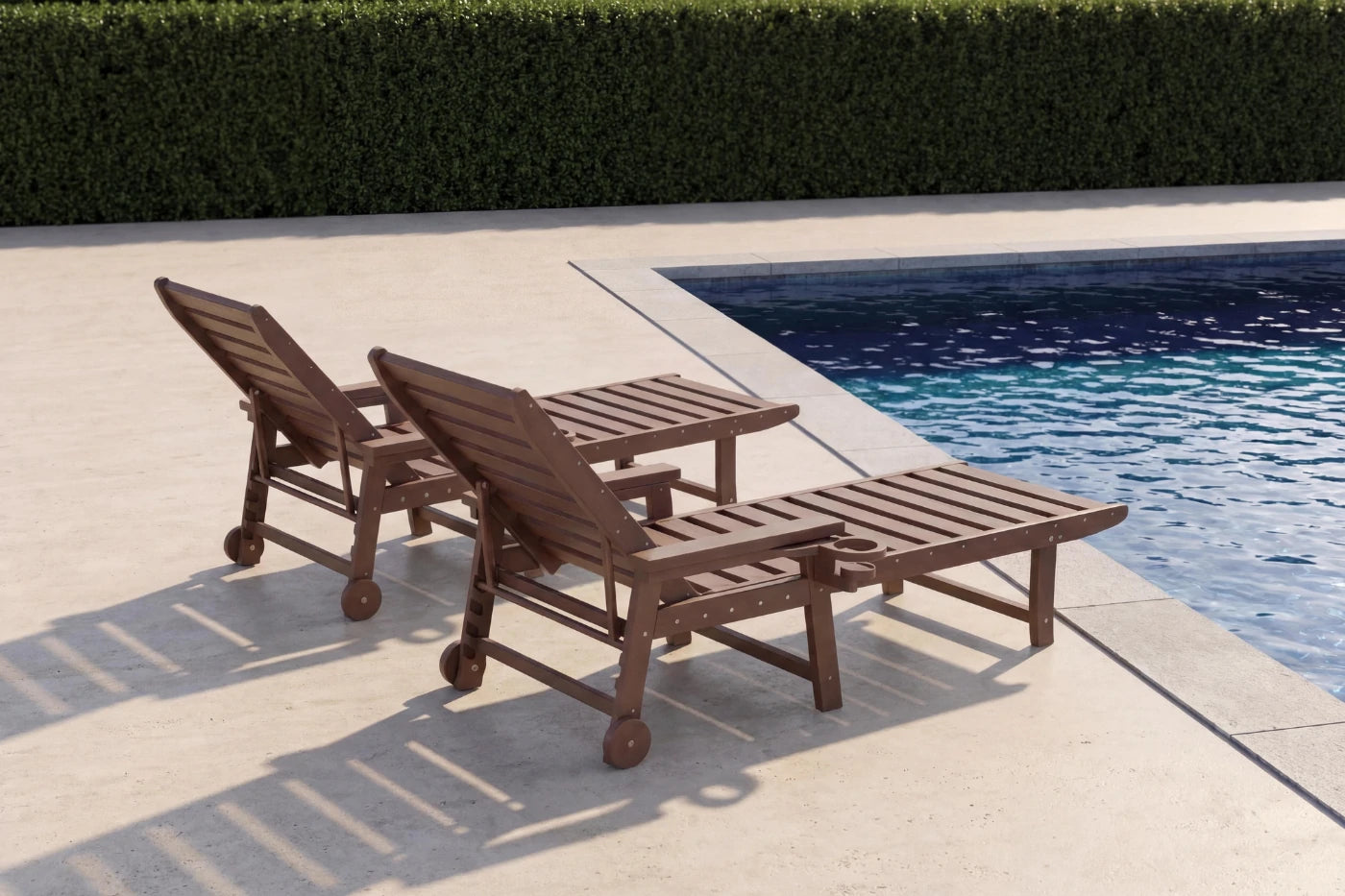 Two wooden lounge chairs by a poolside with a hedge in the background