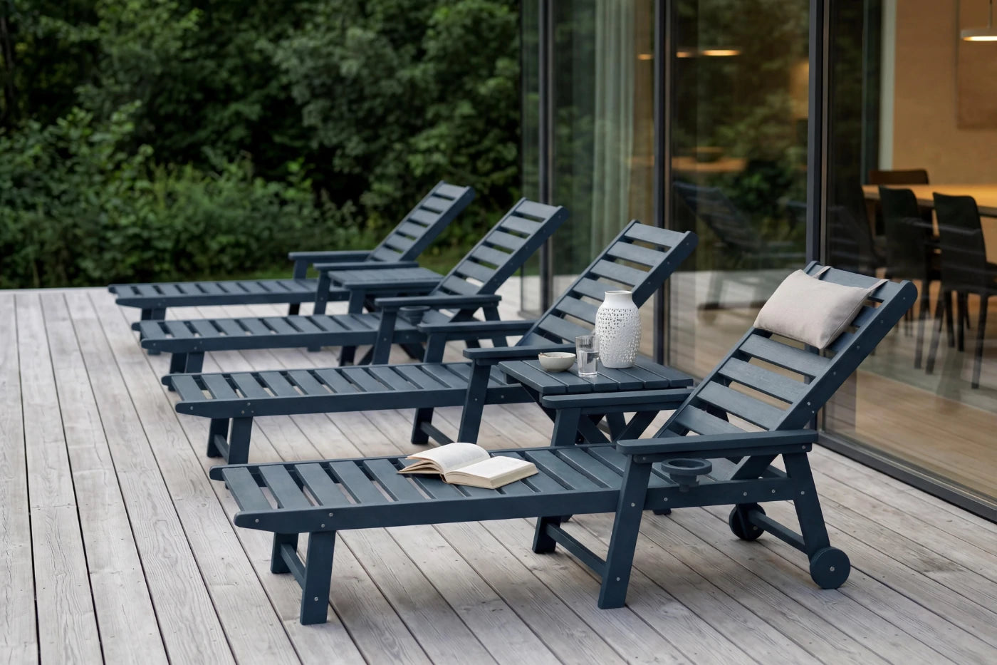 Set of outdoor lounge chairs on a wooden deck with a modern building in the background.