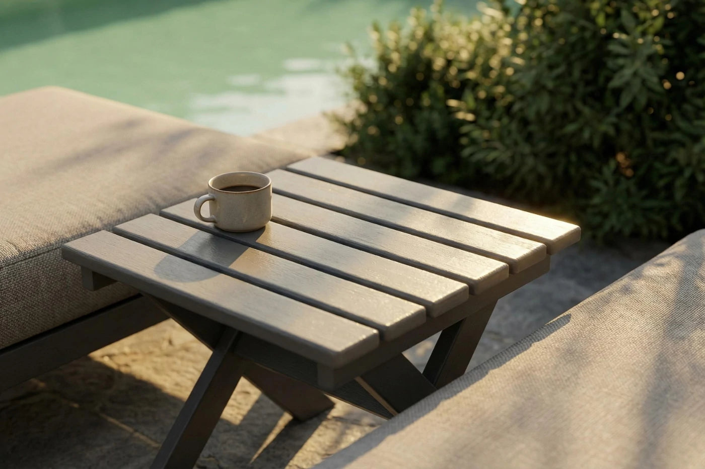 Small wooden table with a cup on it by a poolside