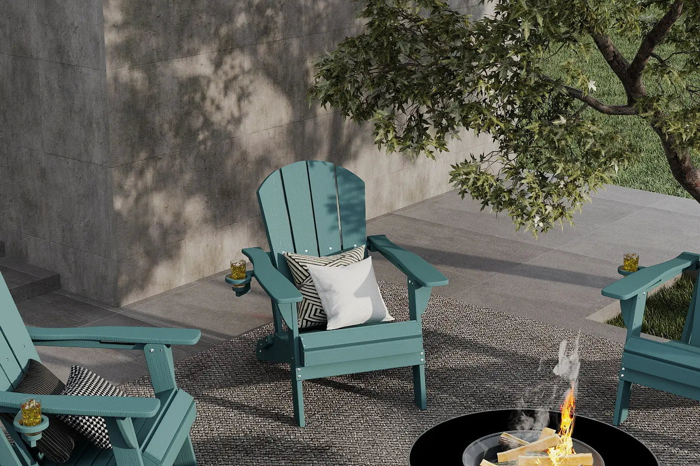 Two teal Adirondack chairs by a fire pit on a patio with a tree in the background.