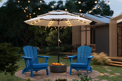 Two blue Adirondack chairs under a large patio umbrella with string lights on a patio.