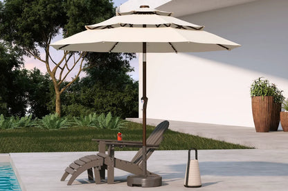 Beige patio umbrella with stand on a patio area with a pool and garden.