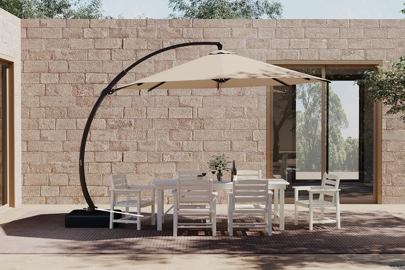 Outdoor patio set with a large umbrella and chairs in front of a stone wall.