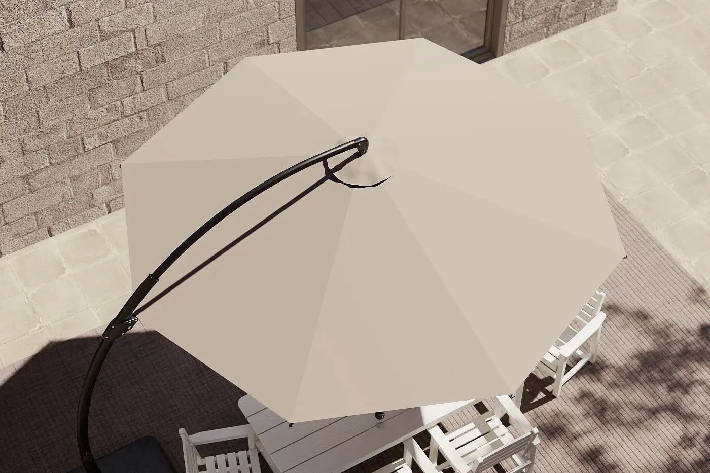 Beige patio umbrella on a stand in an outdoor setting with a stone wall background