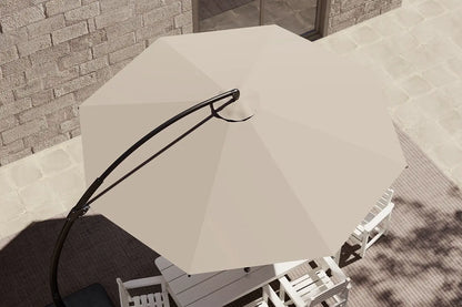 Beige patio umbrella on a stand in an outdoor setting with a stone wall background