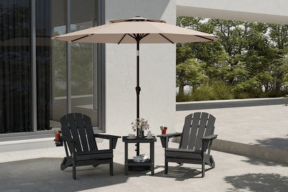 Two black Adirondack chairs with a beige umbrella on a patio.