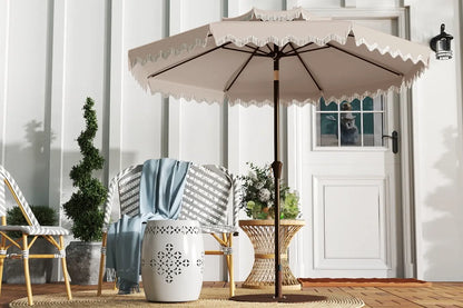 Beige patio umbrella with decorative trim on a wooden deck.