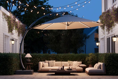 Outdoor patio with a large umbrella, couch, and coffee table under string lights.