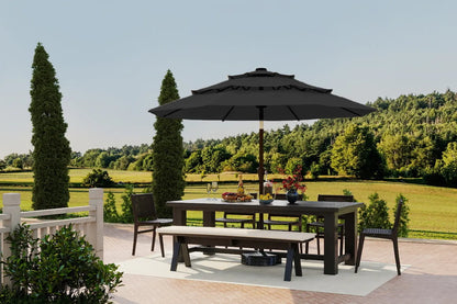 Outdoor dining set with table, chairs, and umbrella on a patio with a scenic background.