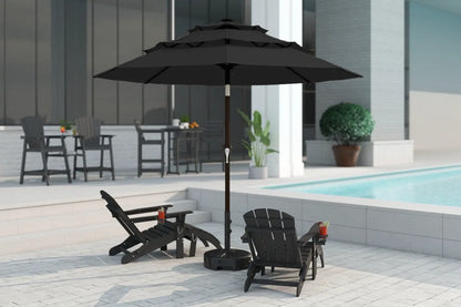 Black patio umbrella with chairs and a table on a patio near a pool.