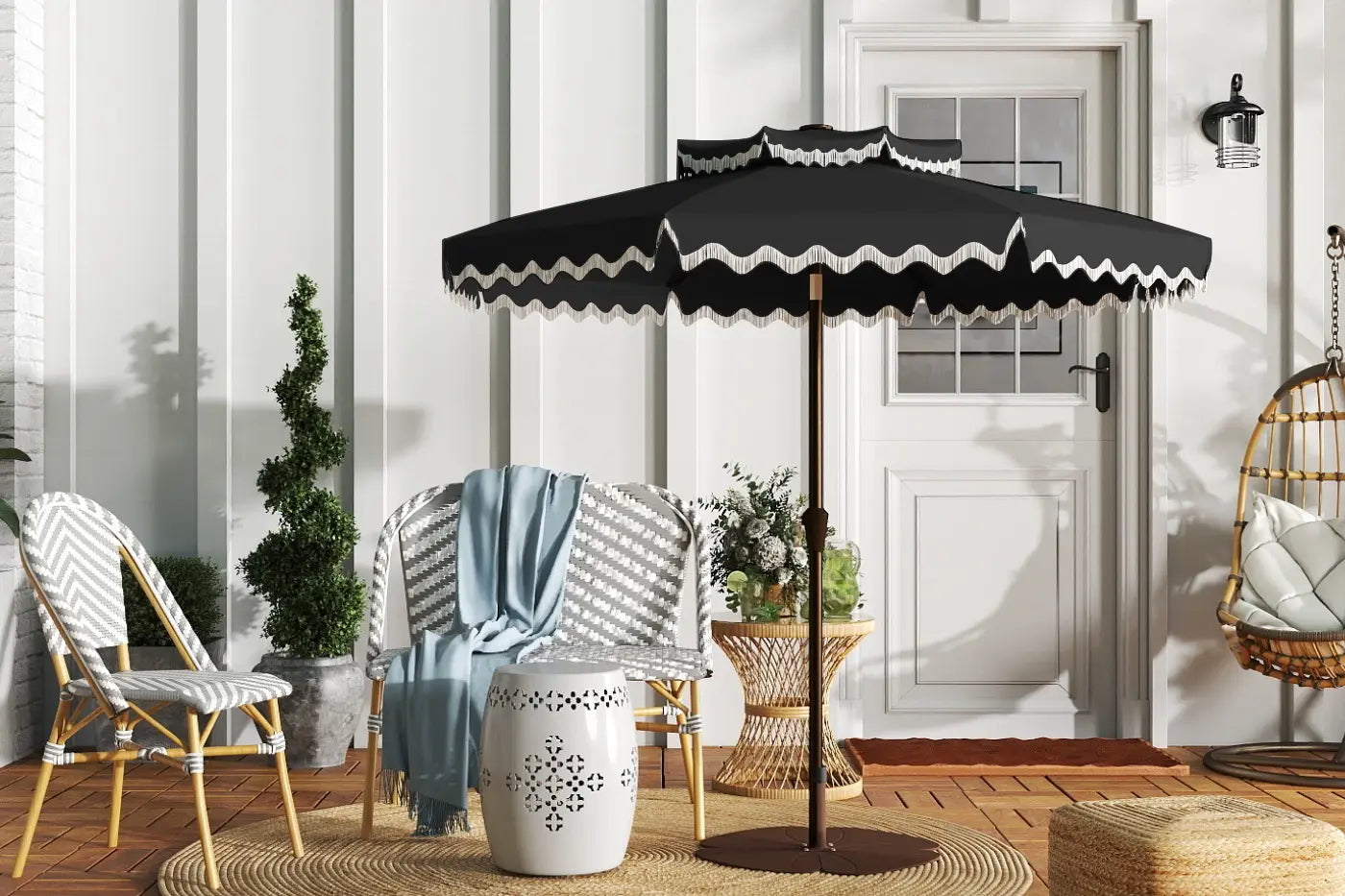 Outdoor patio setting with a black umbrella, chairs, and decorative elements.