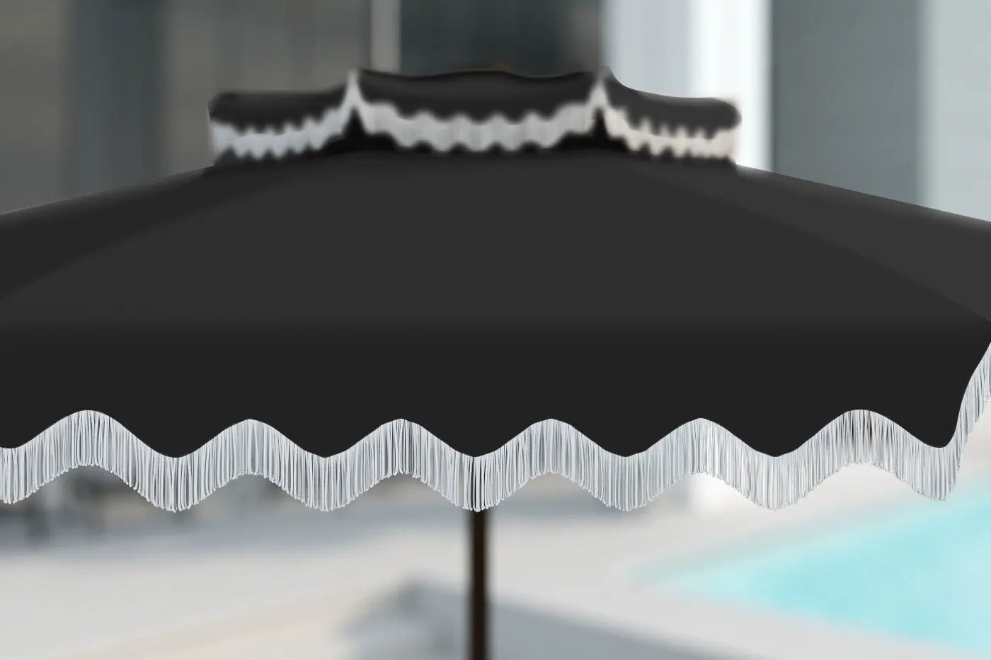 Black outdoor umbrella with wavy edge design on a blurred background