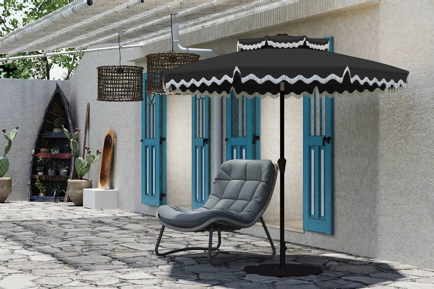 Gray chair under a black patio umbrella with decorative white trim on a stone patio.