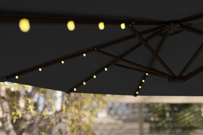 Black outdoor umbrella with string lights against a blurred background