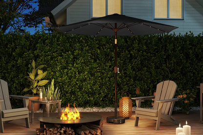 Outdoor patio setting with a fire pit, chairs, and an umbrella at dusk.