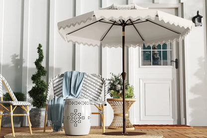 Beige patio umbrella with decorative trim on a wooden deck.
