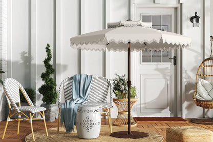 Outdoor patio setting with a large umbrella, chairs, and decorative elements.