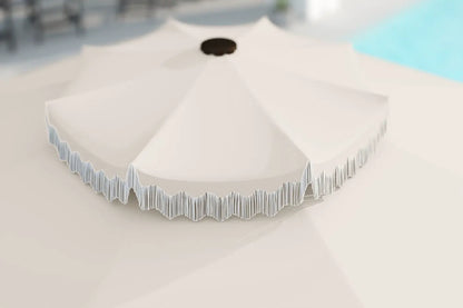 White outdoor umbrella with decorative trim on a light surface