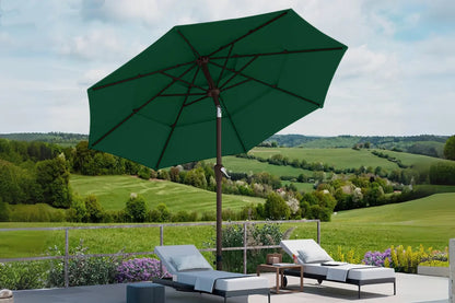 Green patio umbrella over lounge chairs with a scenic background