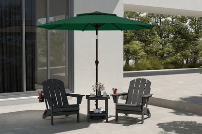 Outdoor patio set with two black chairs and a green umbrella on a concrete patio.