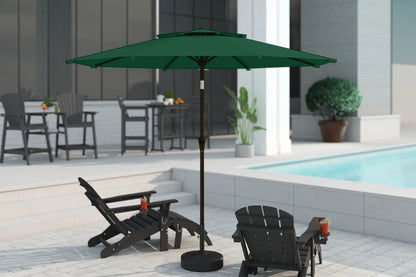 Green patio umbrella on a stand in an outdoor setting with chairs and a pool.