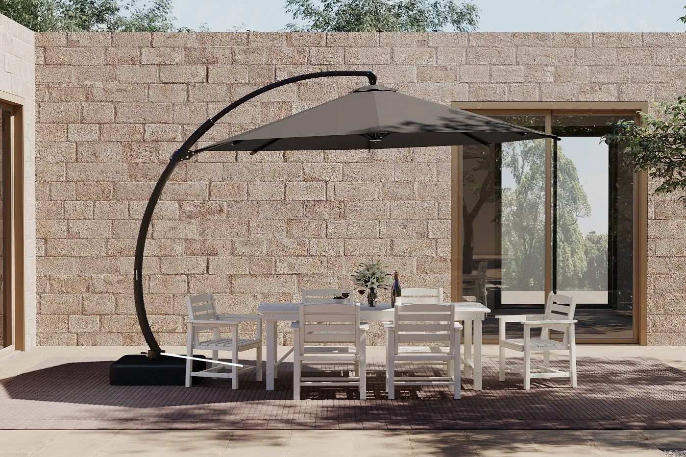 Outdoor patio set with a large umbrella and chairs against a stone wall.
