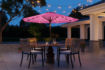 Outdoor patio setting with a pink umbrella and string lights at dusk.