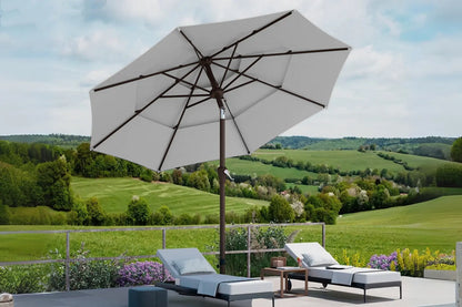 Outdoor patio with lounge chairs and umbrella overlooking a scenic landscape
