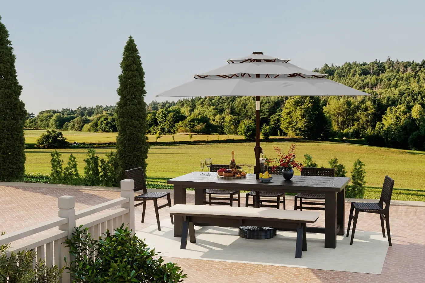 Outdoor patio set with table, chairs, and umbrella on a deck with a scenic background.