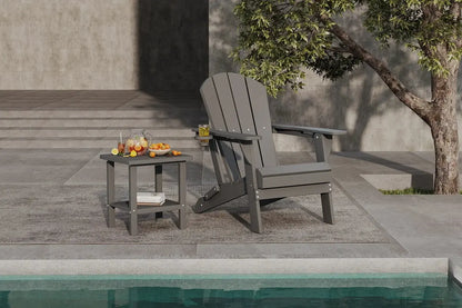 Gray Adirondack chair and small table by a poolside with a tree in the background.