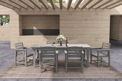Outdoor dining set with table and chairs on a wooden deck under a pergola.