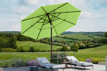 Green patio umbrella over lounge chairs with a scenic background