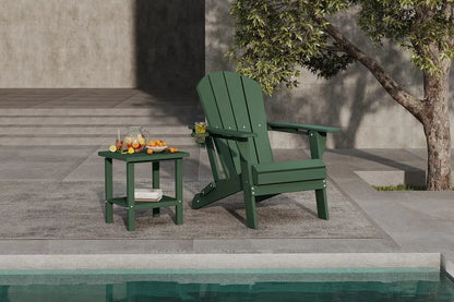 Green Adirondack chair and side table by a poolside with a tree in the background.
