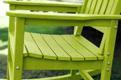 A close-up of an apple green outdoor Adirondack chair with a slatted seat and back, showing silver metal fasteners, set against a blurred green background.