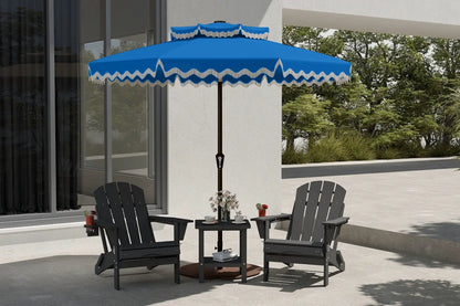 Blue and white striped patio umbrella over two black chairs on a patio.