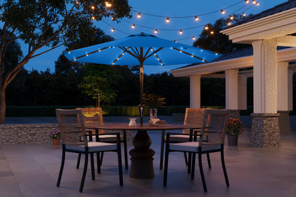 Outdoor patio setting with a table, chairs, and string lights at dusk.