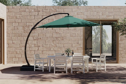 Outdoor patio set with a green cantilever umbrella against a stone wall.