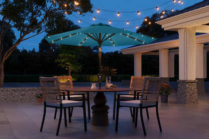 Outdoor patio setting with a table, chairs, and string lights at dusk.