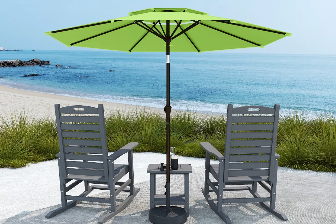 Two gray chairs with a green umbrella on a sandy beach.