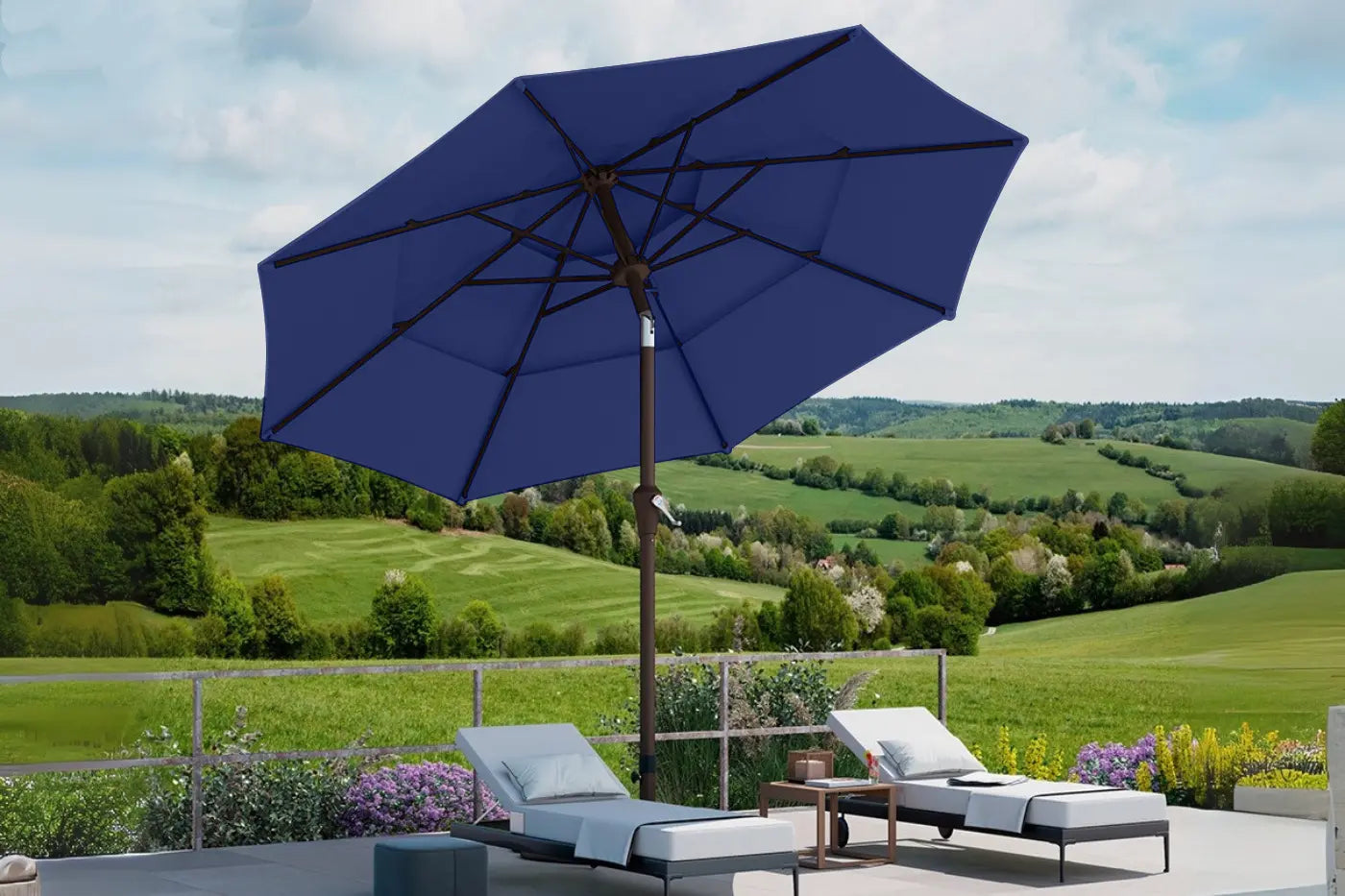 Blue patio umbrella with lounge chairs and a scenic background